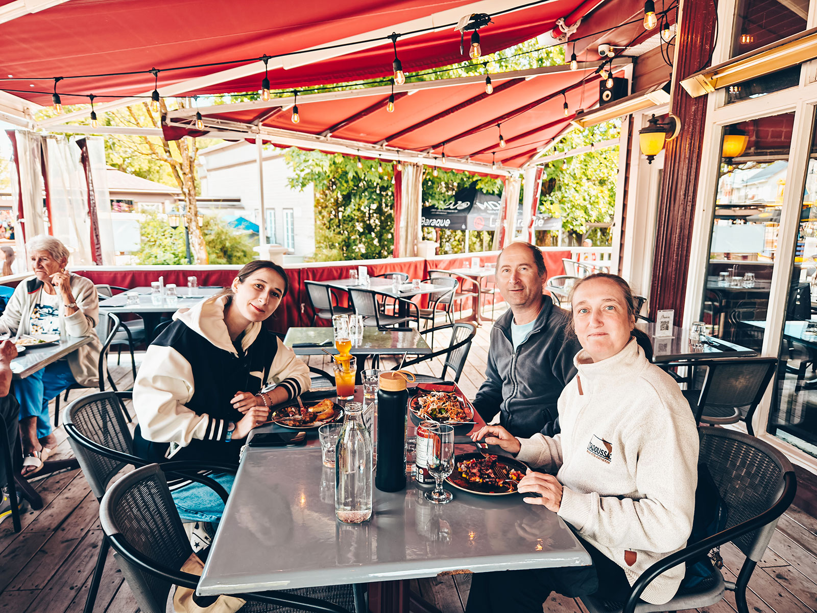 Trois personnes attablées sur la terrasse du restaurant