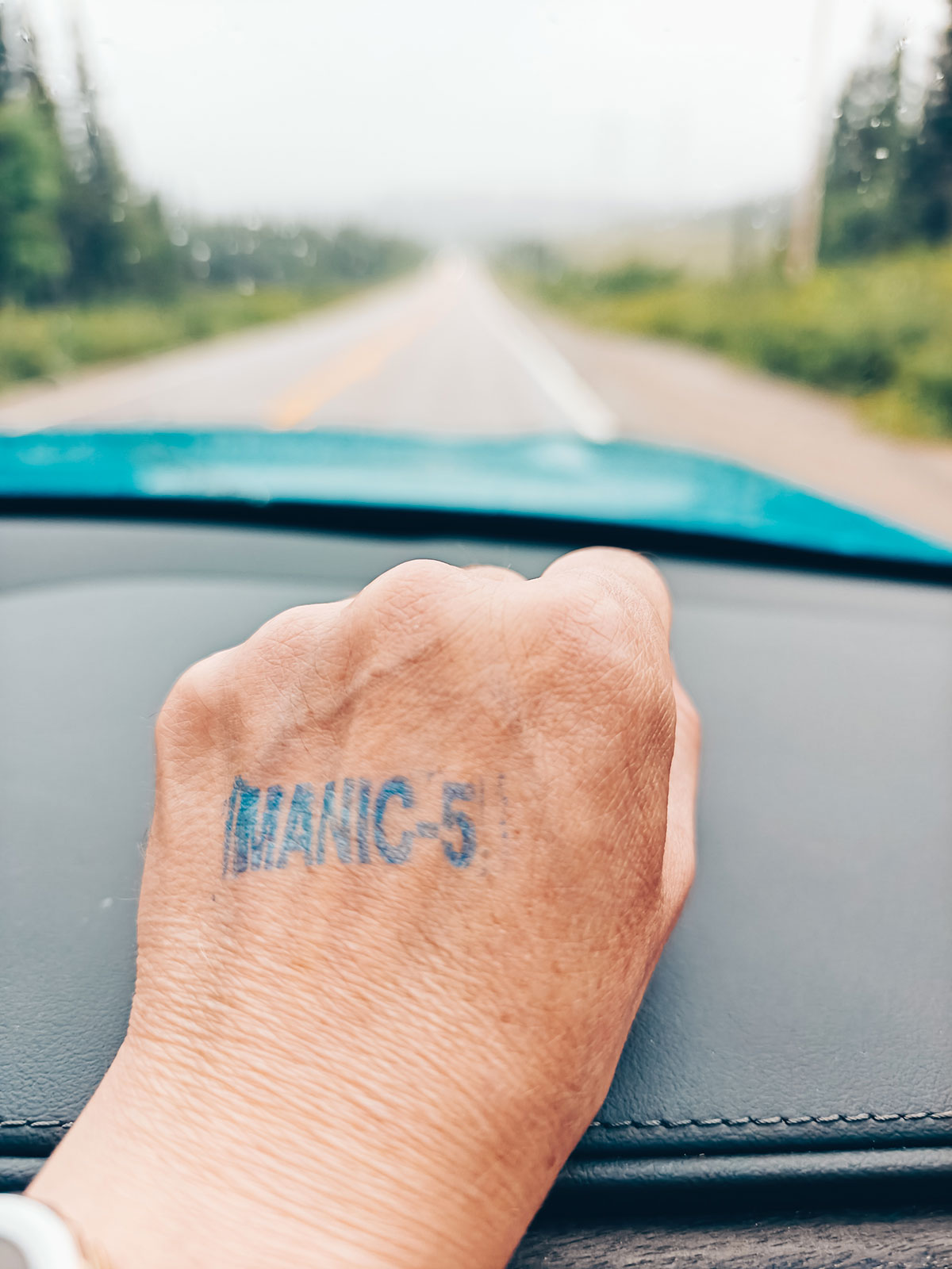 Une main marquée d'un tampon à l'encre où on lit Manic-5