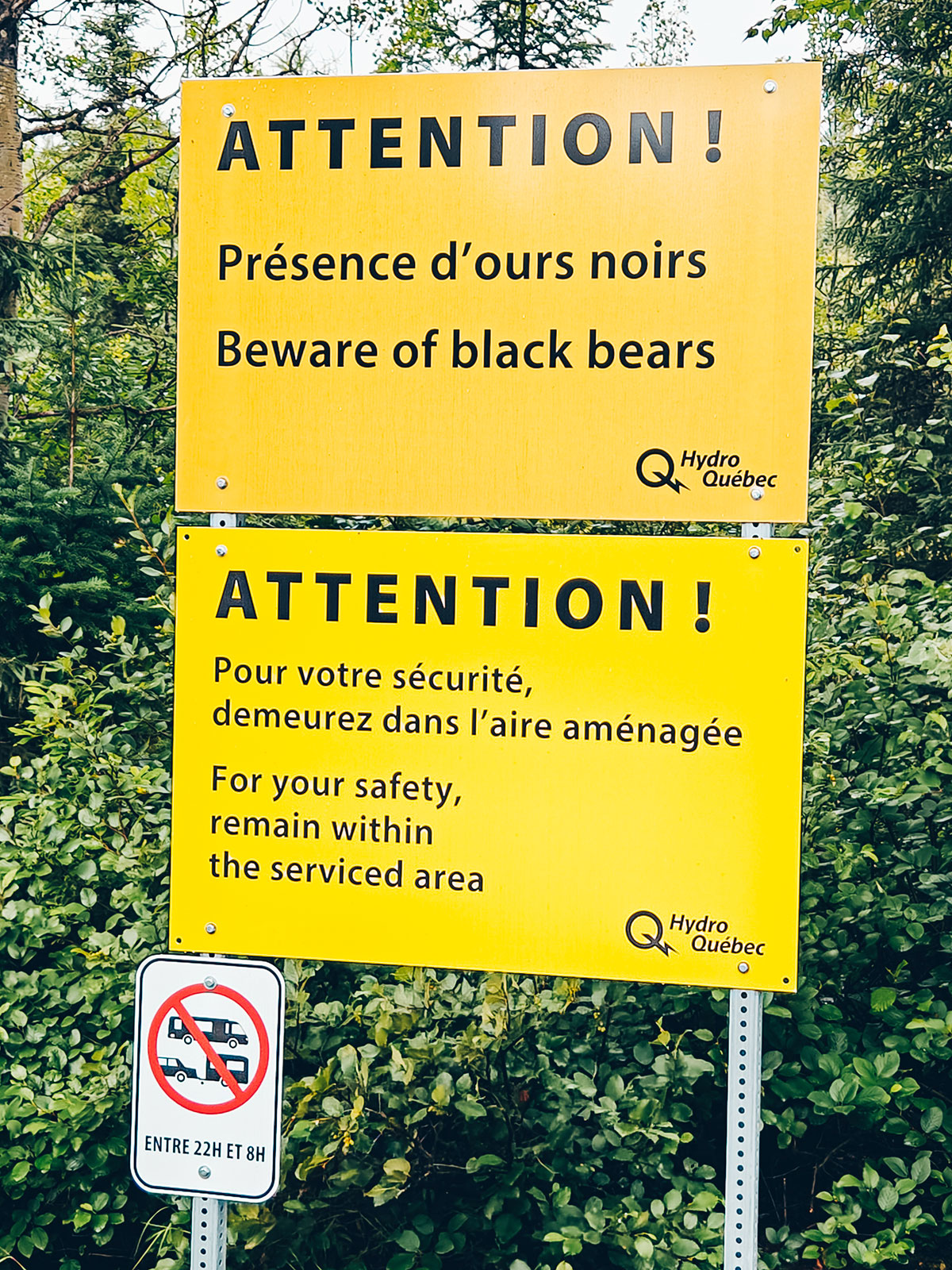 Deux panneaux jaunes d'Hydro-Québec avertissant de la présence d'ours noirs