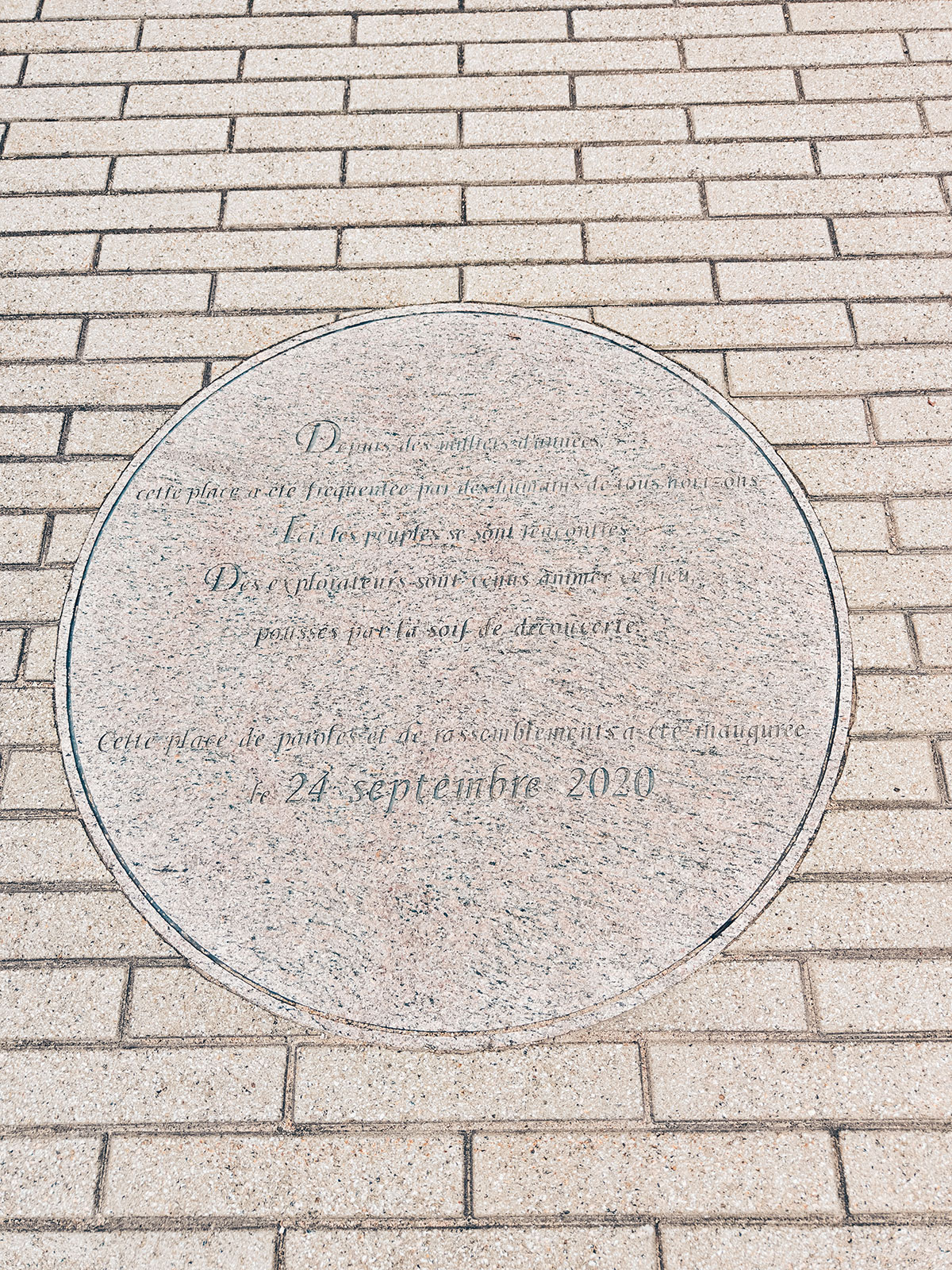 Une plaque commémorative ronde encastrée dans un mur de pierre