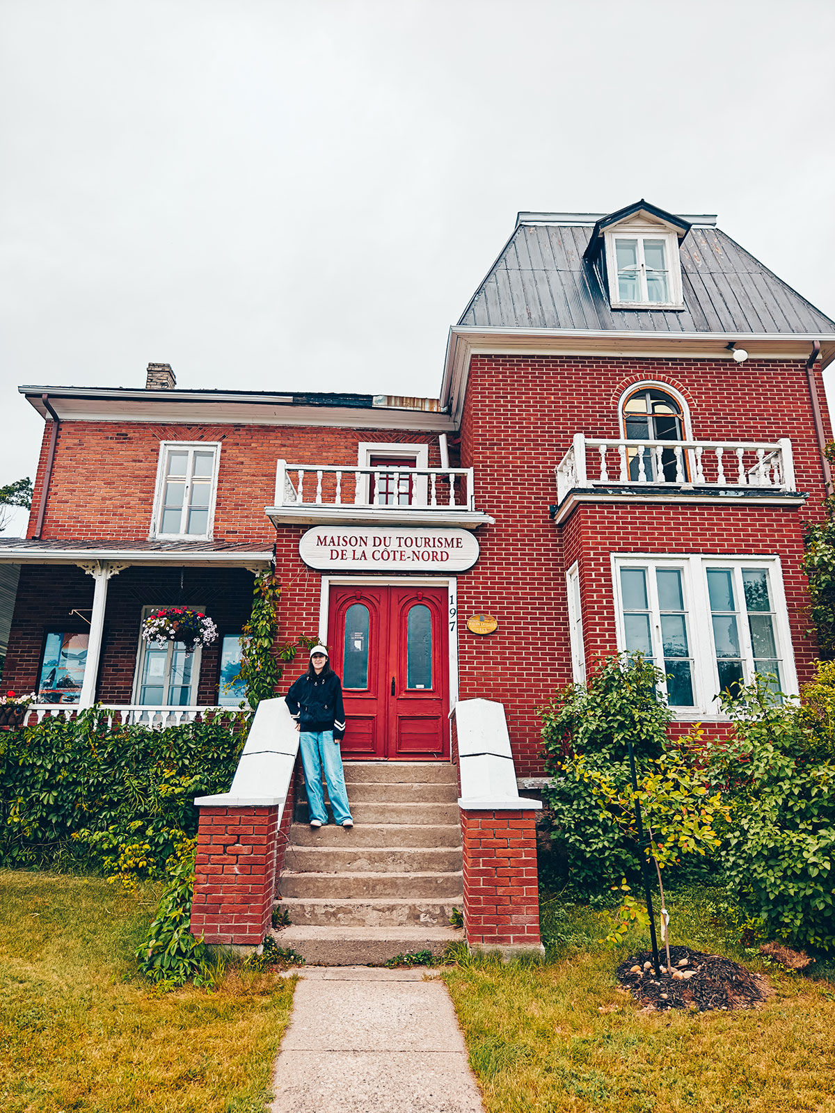 Une maison patrimoniale de brique rouge, des gens sur les marches