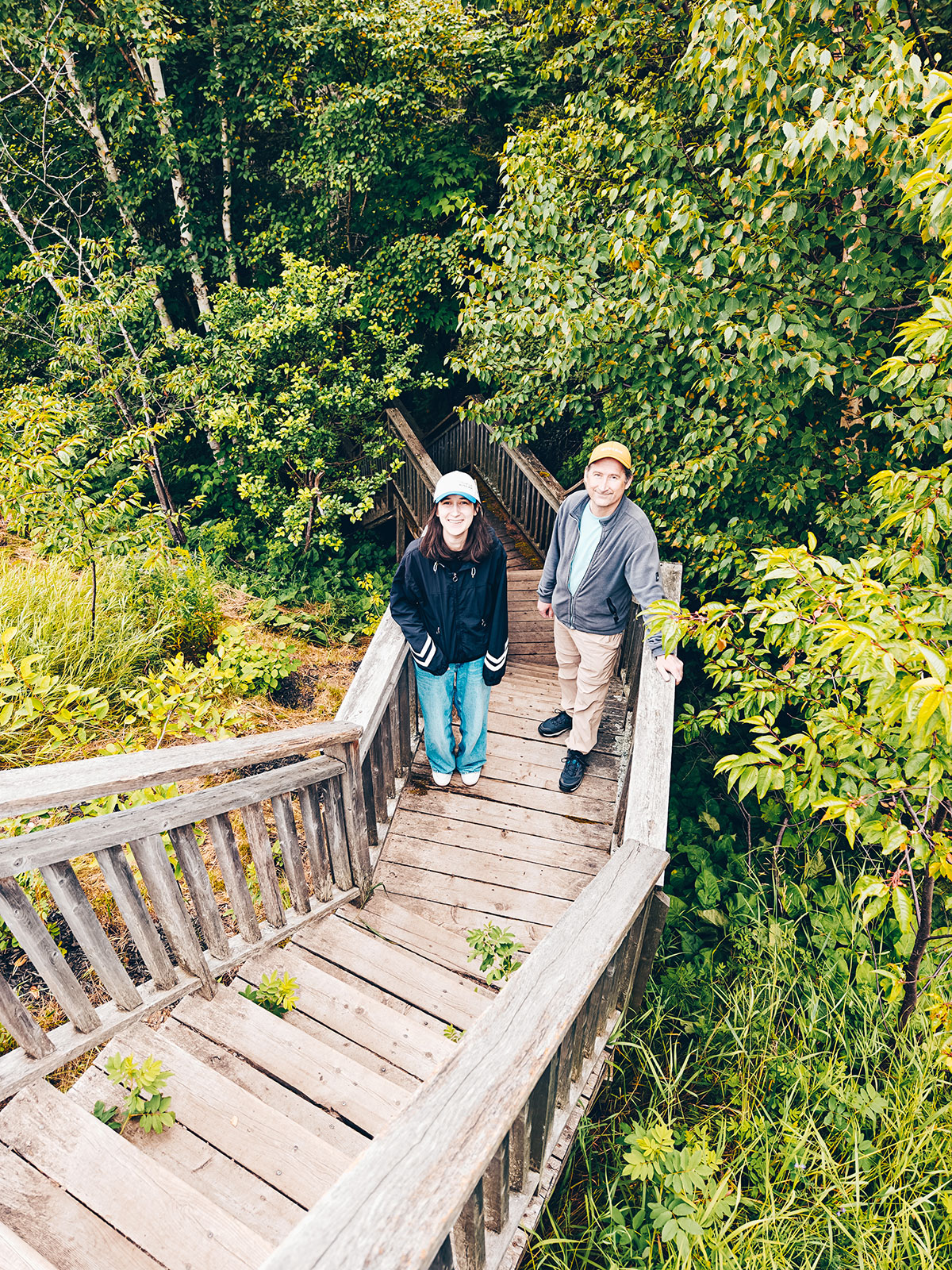 Deux personnes descendant un escalier de bois dans les arbres