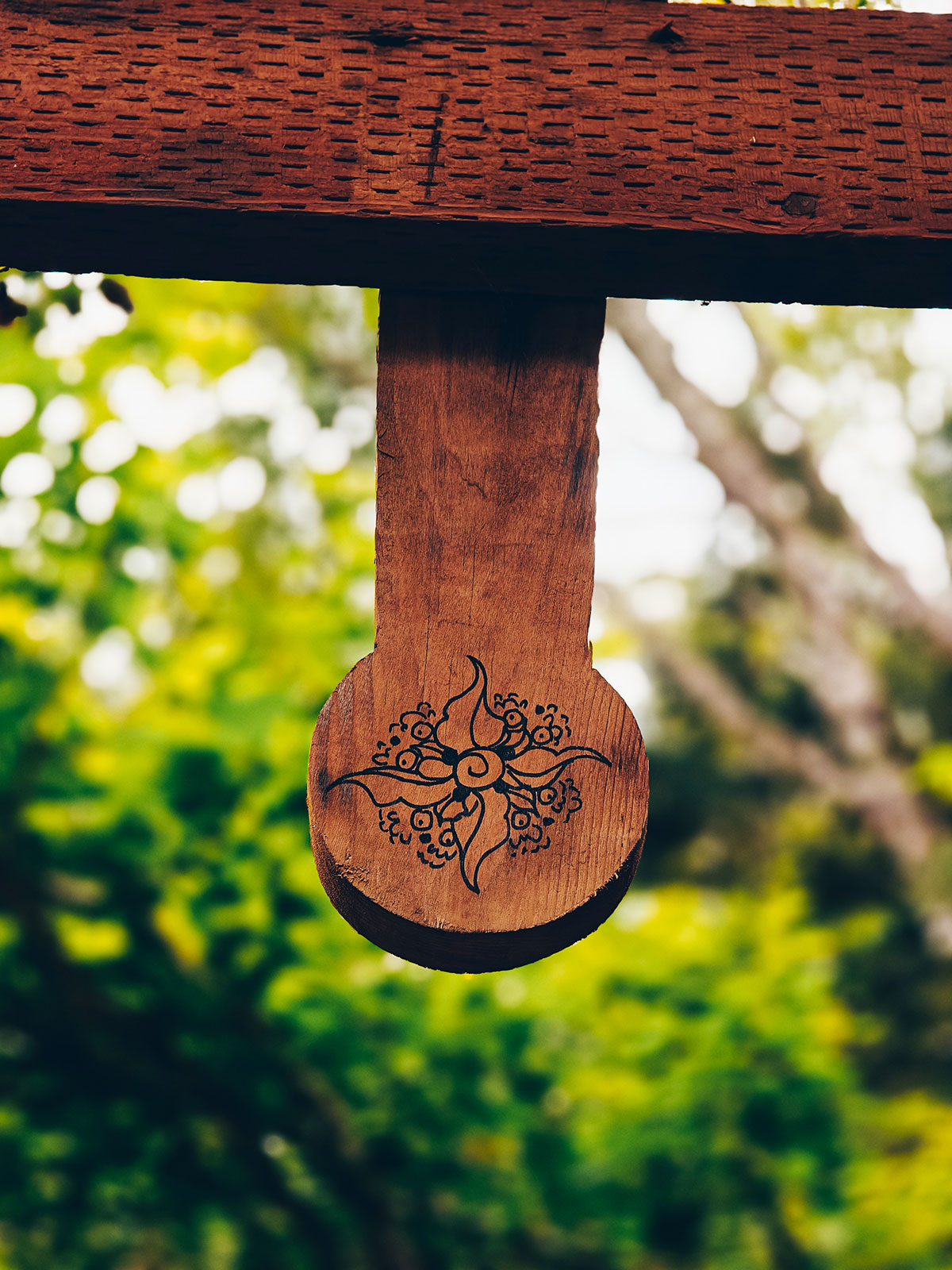 Un pendentif de bois sculpté suspendu, vu de près