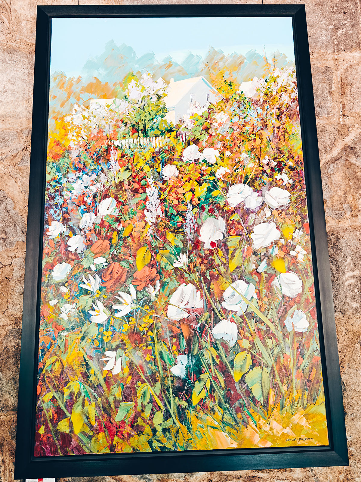 Un tableau encadré de fleurs blanches et jaunes, très coloré