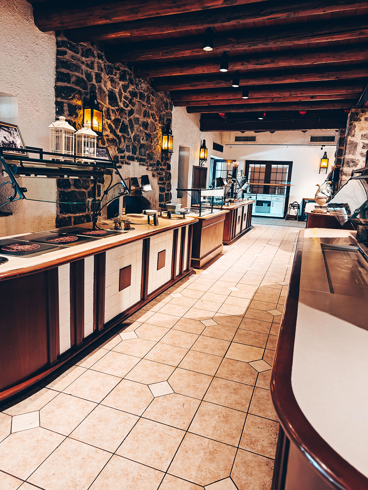 Le comptoir de service du restaurant, mur de pierre et sol en tomettes hexagonales