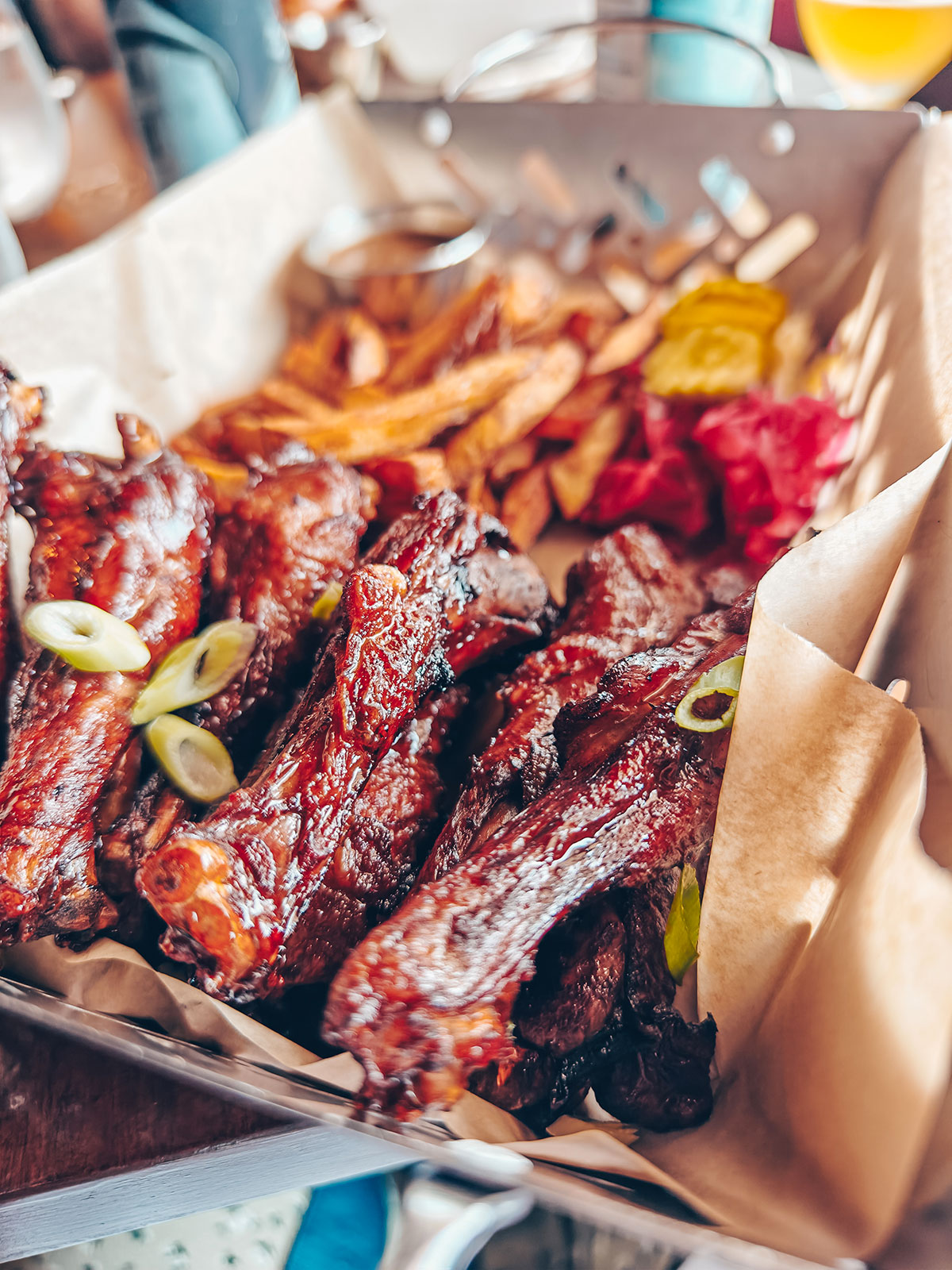 Une portion de côtes levées laquées, servie avec des frites dans un panier
