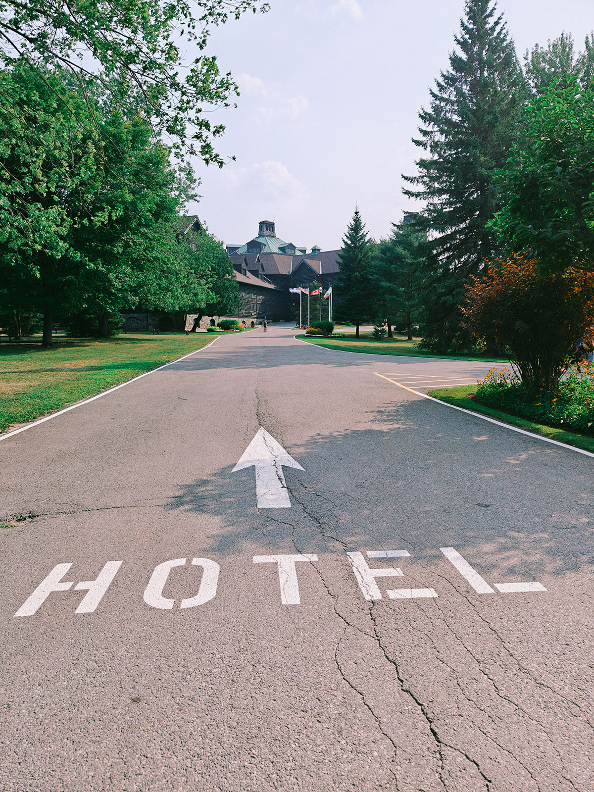 Le mot HOTEL et une flèche peints à même l’asphalte de l’allée