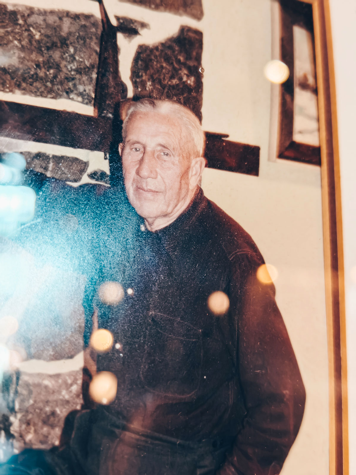 Une photographie encadrée d’un homme âgé, en manteau sombre