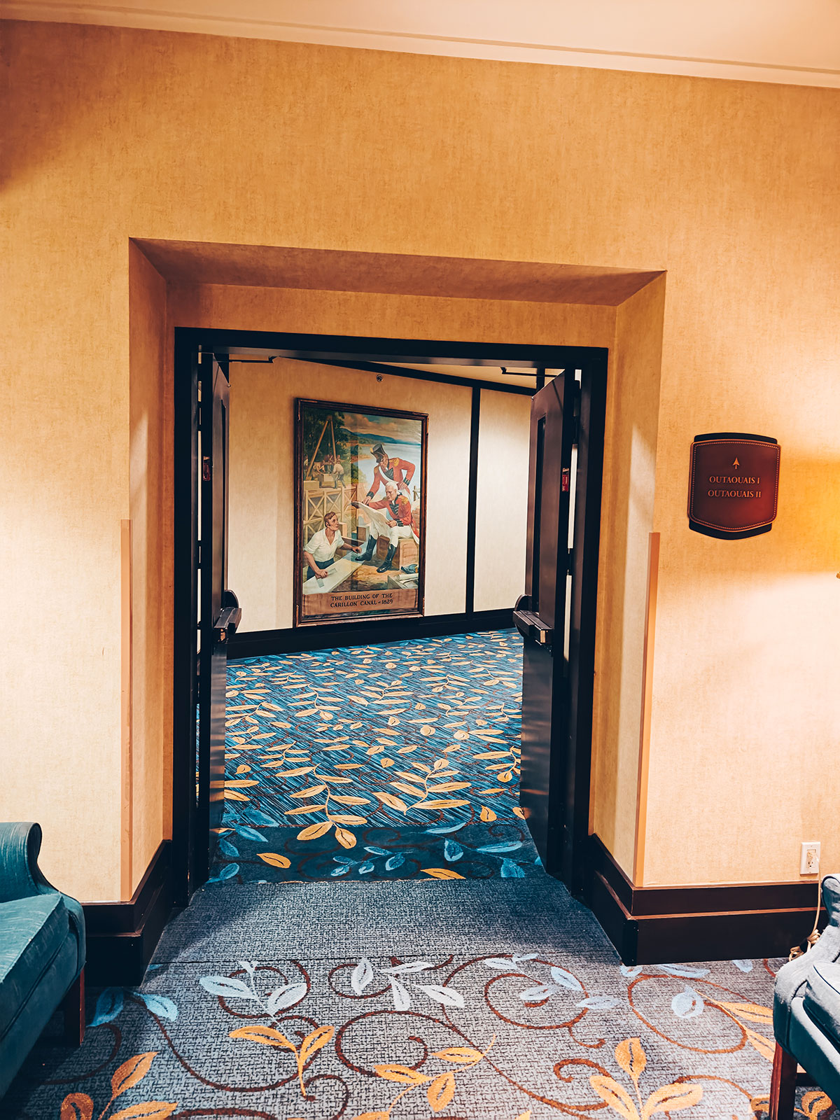 Un couloir d’étage, un tableau au mur et un tapis à motifs