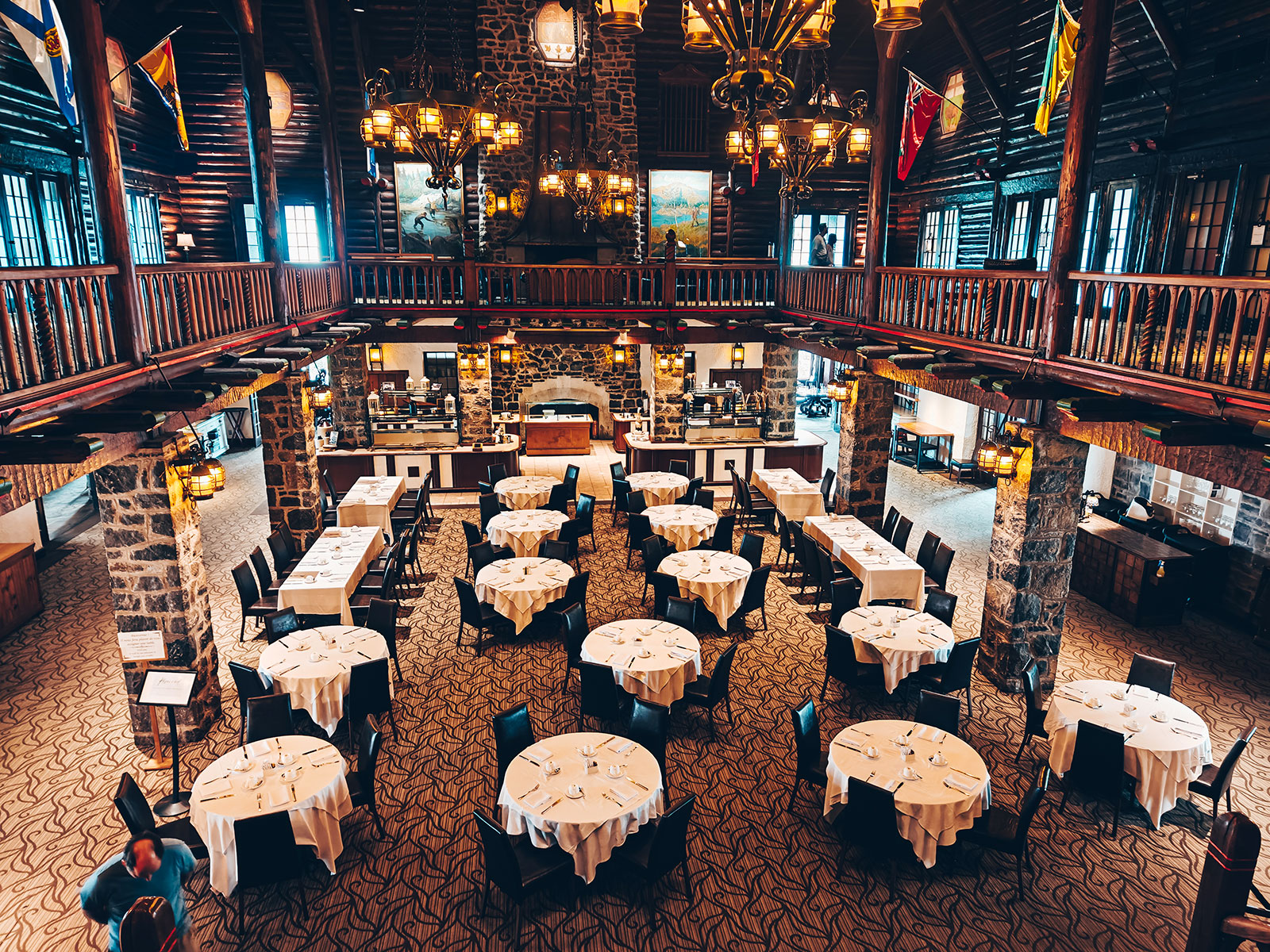 La grande salle à manger vue d’en haut : tables rondes, lustres et drapeaux