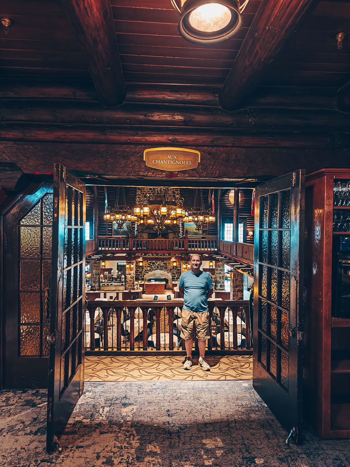 Le vestibule d’entrée, un visiteur debout sous l’arche de bois