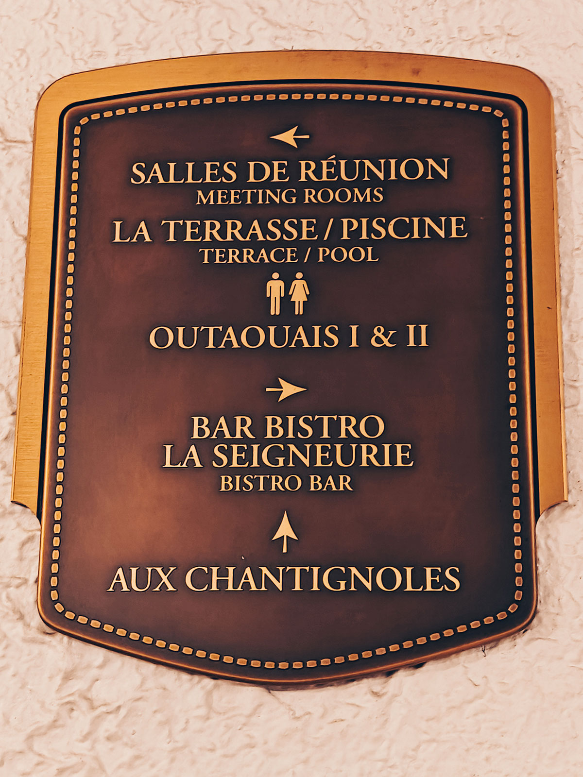 Le panneau de laiton listant les salles : réunions, terrasse et piscine, Outaouais I et II, bar bistro La Seigneurie, Aux Chantignoles