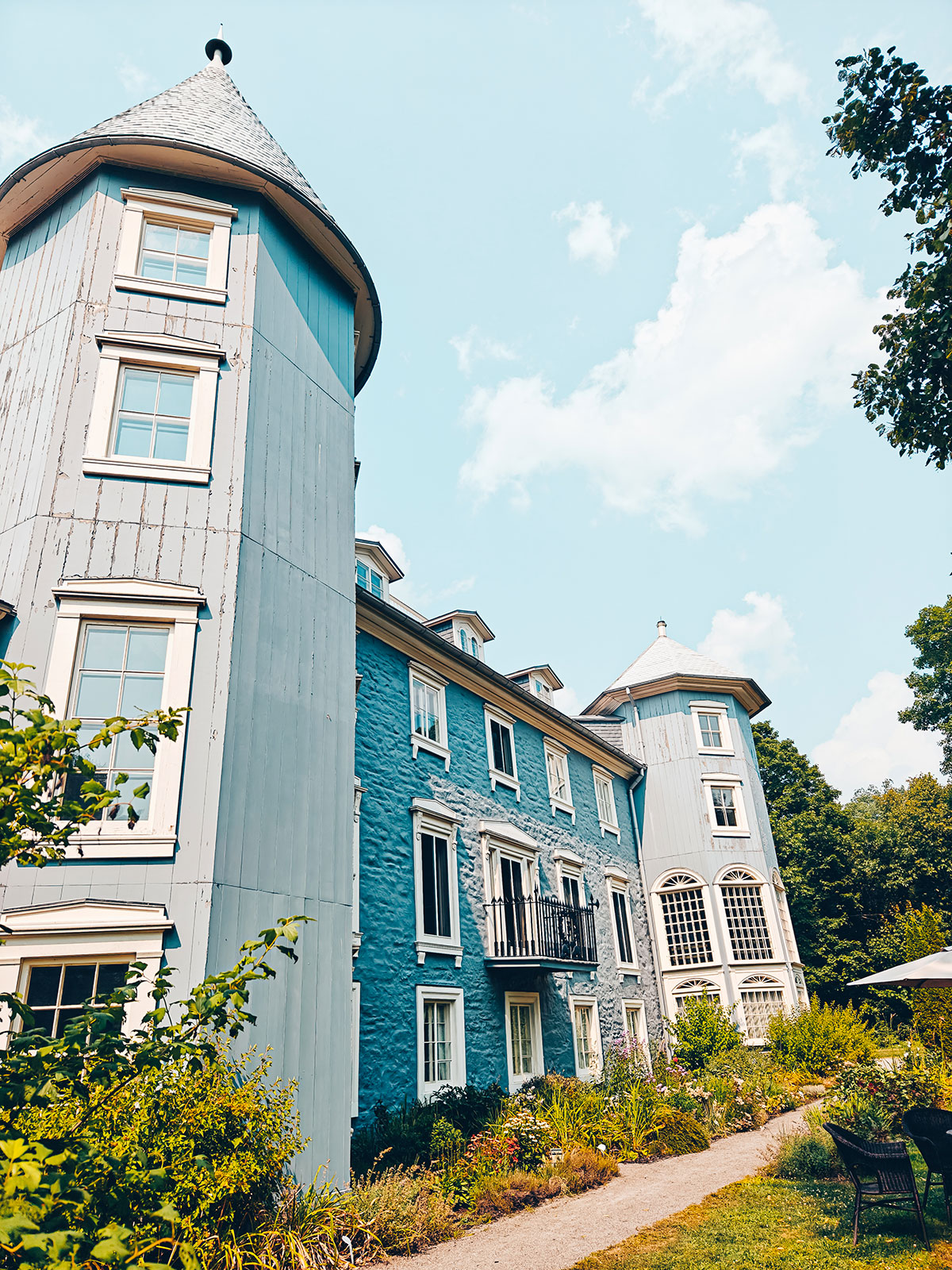 La façade complète du manoir avec sa tour, dans la verdure