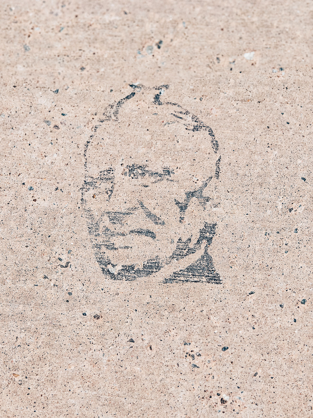 Un visage dessiné à même une dalle de pierre claire