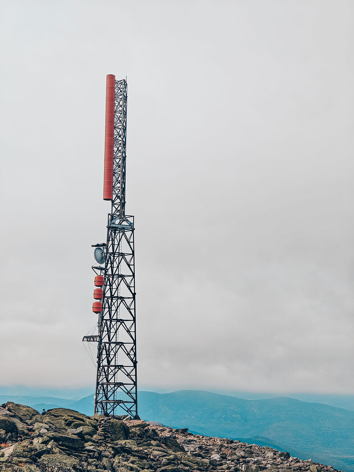 Le grand pylône de transmission rouge et blanc, dans le ciel gris