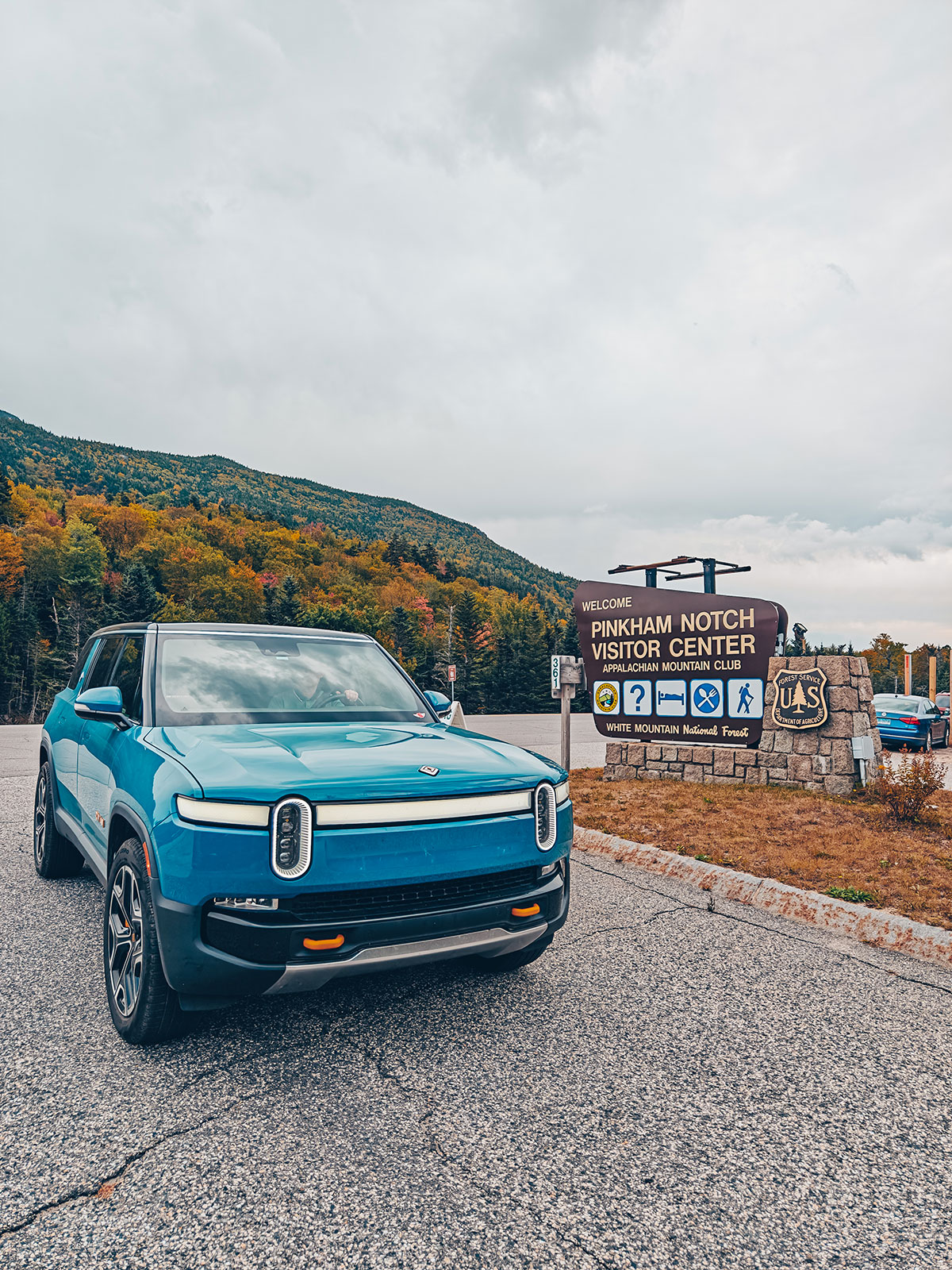Le Rivian devant le panneau du centre d'accueil