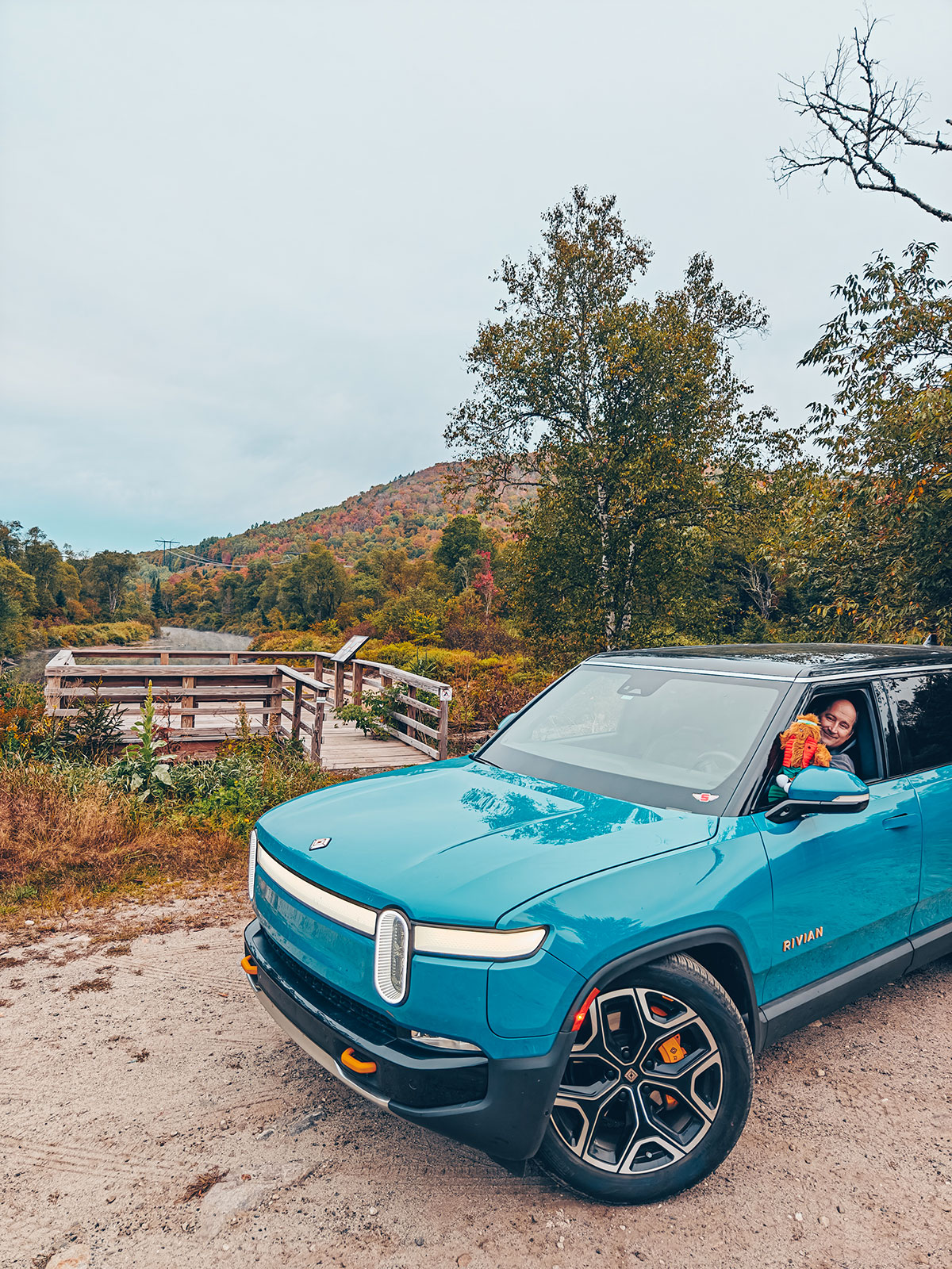 Le Rivian arrêté au belvédère de bois, quelqu'un à la fenêtre