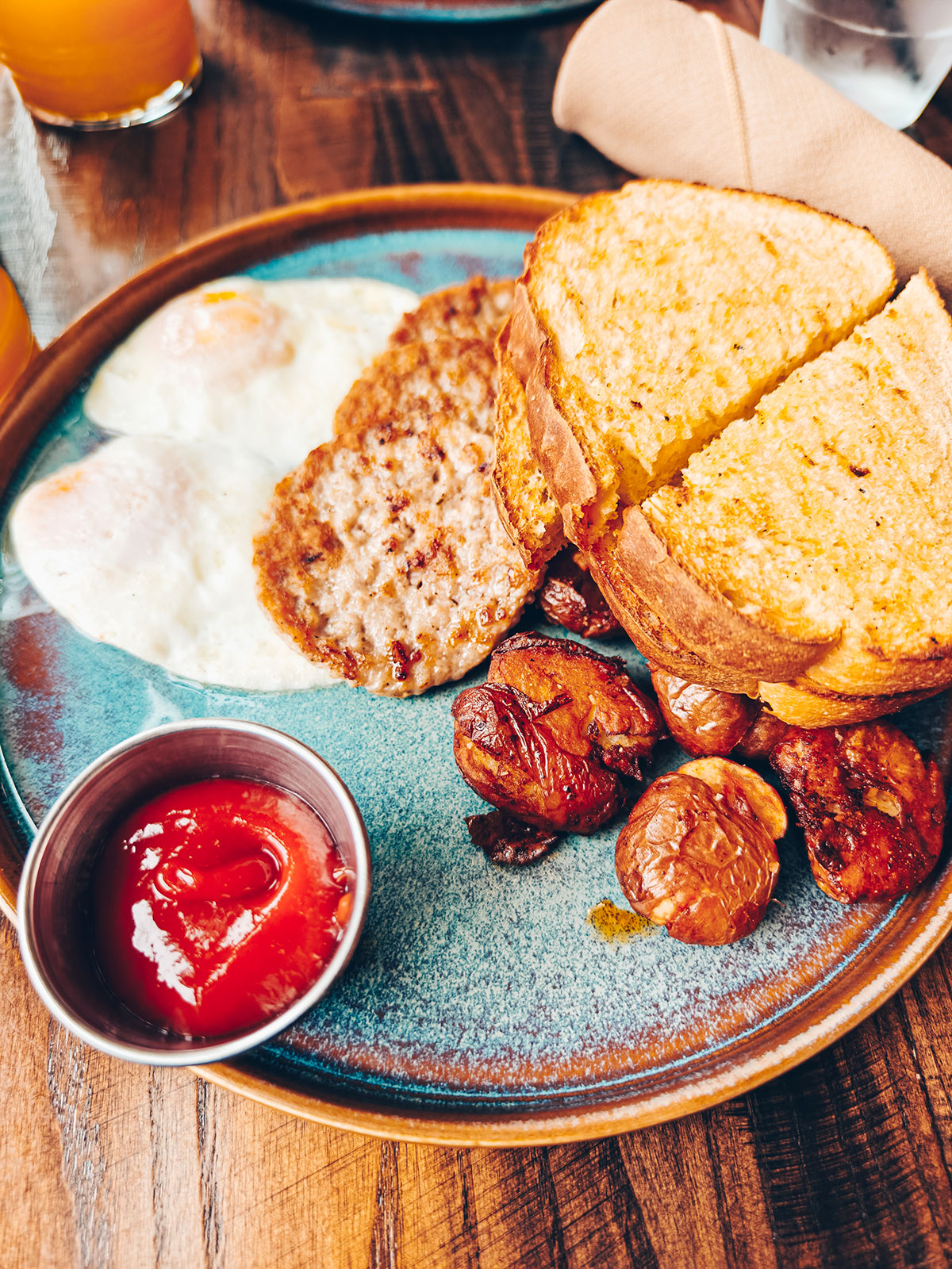 Une assiette : œufs, rôties, pommes de terre rissolées et ketchup
