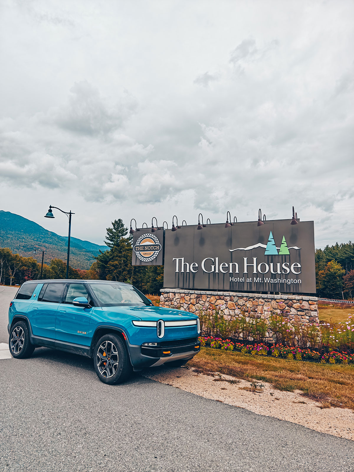 Le Rivian devant l'enseigne de l'hôtel
