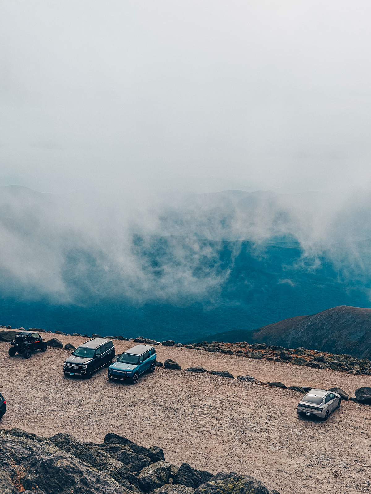 La brume monte de la vallée et déborde sur le stationnement