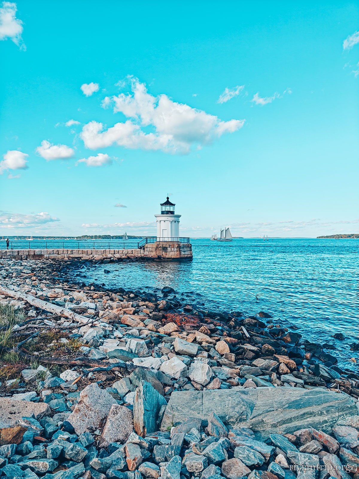 Le petit phare blanc au bout de son brise-lames de granit