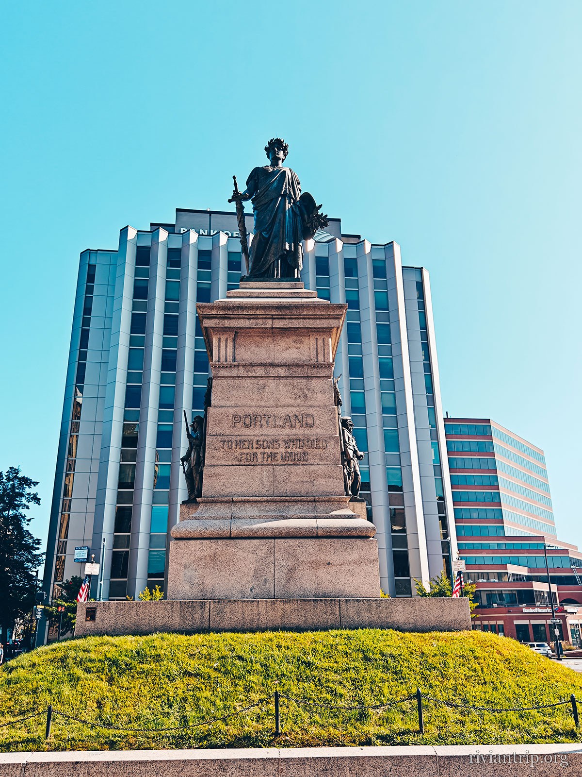 Un monument de granit surmonté d’une statue de bronze