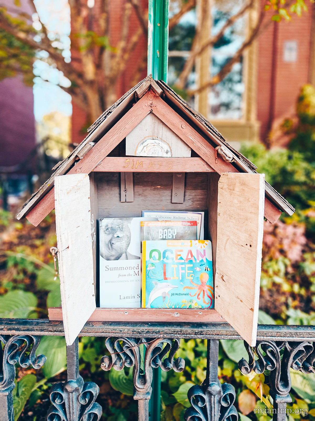 Une petite bibliothèque libre accrochée à un poteau